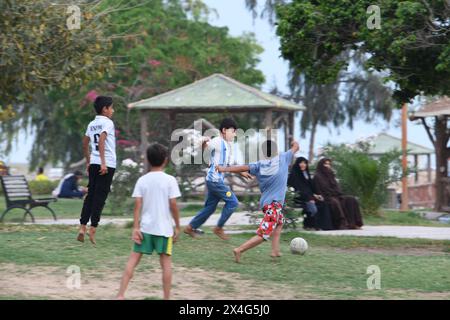 Bushehr, Iran. 28 avril 2024. Des enfants jouent au football à Bushehr, Iran, le 28 avril 2024. Située sur la côte du golfe Persique, Bushehr est une ville portuaire majeure du sud de l'Iran. Crédit : Shadati/Xinhua/Alamy Live News Banque D'Images