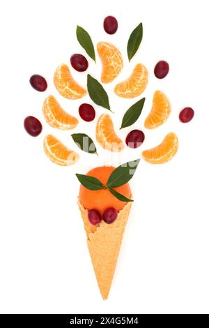 Cône de crème glacée surréaliste avec mandarine, fruits de canneberge et feuilles sur fond blanc. Concept de nourriture saine et amusante. Riche en antioxydants. Banque D'Images