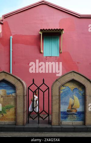Une femme marche derrière la porte dans un bâtiment coloré dans Arab Street, Kampong Glam, le quartier musulman de Singapour Banque D'Images