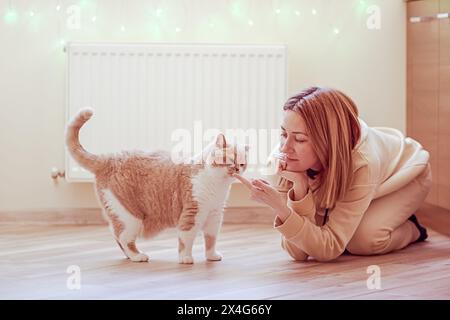Portrait d'une jeune femme avec son chat à la maison Banque D'Images