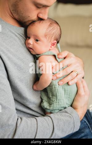 Gros plan du père embrassant un nouveau-né tout en le tenant dans les bras Banque D'Images