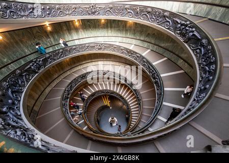 Escalier en colimaçon avec des balustrades en métal ornées dans un des musées du Vatican, vu d'en haut avec les gens qui descendent. Escalier hélicoïdal Bramante Banque D'Images
