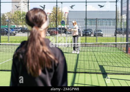 Ukraine Kiev, 20 avril 2024. joyeuse jolie fille pratiquant le sport de paddle sur le court de paddle Banque D'Images