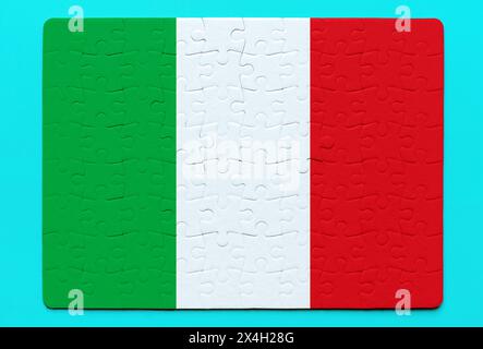 Pièces de puzzle assemblées dans le drapeau national de l'Italie sur un fond bleu vif. Unité, nationalisme et résolution de problèmes liés à la conception Banque D'Images