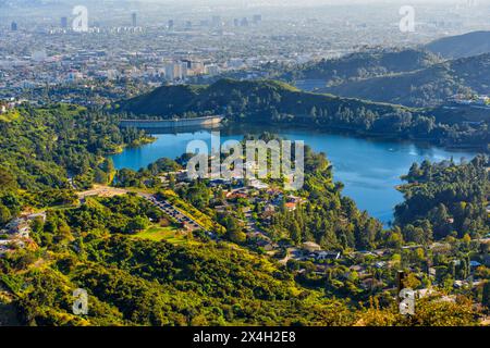 Hollywood Reservoir sur fond de maisons tentaculaires et de routes sinueuses. Concept de coexistence urbaine et naturelle. Banque D'Images