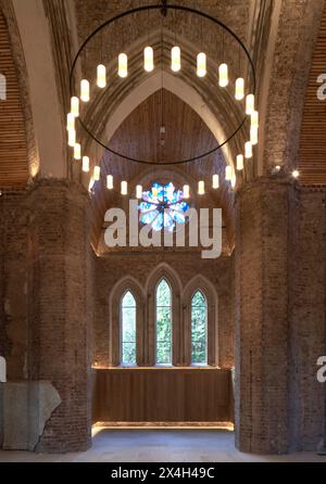 Lunette arrière gothique voûtée avec vue sur le cimetière. Abney Park Chapel, Londres, Royaume-Uni. Architecte : Kaner Olette Architects, 2023. Banque D'Images