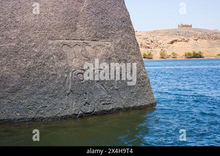 Roche partiellement submergée avec des sculptures pharaoniques dans le Nil juste à l'extérieur du complexe du temple de Philae (un site du patrimoine mondial de l'UNESCO) en Nubie, Egypte Banque D'Images