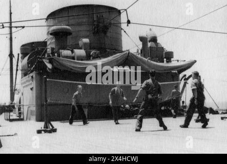 Années 1940 – un groupe de soldats de l'armée britannique jouant à Tennikoit sur le pont d'un navire de troupes pendant la seconde Guerre mondiale. Aussi connu sous le nom de Ring Tennis, le Tennikoit est un sport pratiqué sur un court de tennis, avec un anneau circulaire en caoutchouc. Banque D'Images