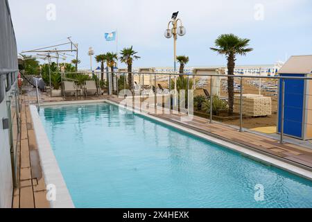 Lido di Jesolo, Italie - 2 mai 2024 : une piscine d'un hôtel sur la plage de Lido di Jesolo en Italie *** Ein Pool von einem Hotel am Strand von Lido di Jesolo in Italien Banque D'Images