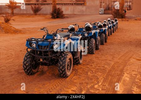 Les quads bleus se dressent dans une rangée sur la rive du désert du Sahara. Banque D'Images