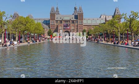 Amsterdam, pays-Bas - 15 mai 2018 : groupe de personnes devant le Rijksmuseum Musée national néerlandais des Arts et de l'histoire vue sur l'étang d'eau. Banque D'Images