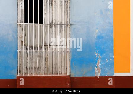 229 mur coloriste de la maison coloniale montrant la fenêtre habituelle, à volets en bois, longue grille comme une porte sur la façade bleu-marron-orange-blanc. Trinidad-Cuba. Banque D'Images