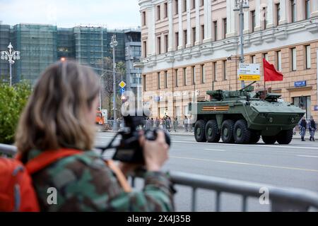 Jeune fille photographie le porte-blindés russe Boomerang sur la rue Tverskaya lors d'une répétition du défilé de la victoire Banque D'Images