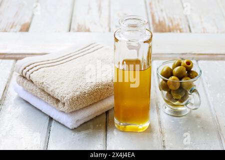 Bouteille en verre d'huile dorée sur fond en bois. Heure du spa Banque D'Images