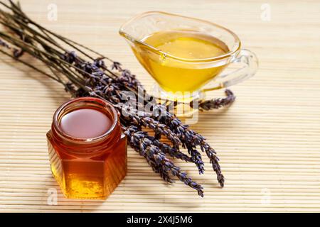 Pot et saucière pleine de miel liquide et Bouquet de lavande d'aliments sains. Banque D'Images