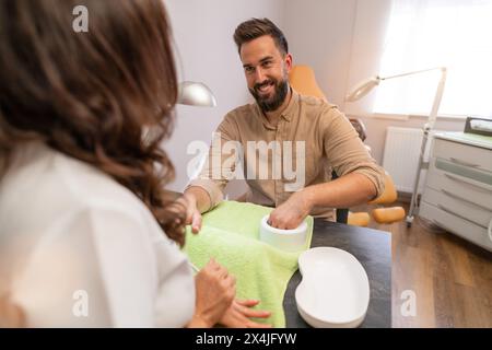 Femme manucure donnant manucure à l'homme souriant dans un salon de beauté. image du concept de soin spa de soins corporels Banque D'Images