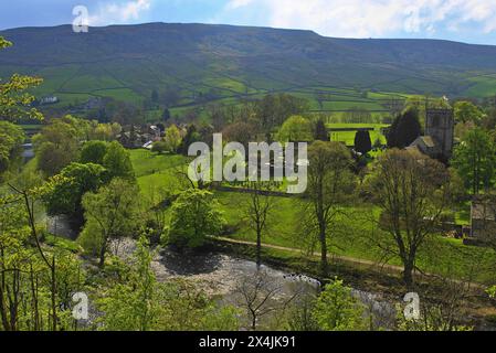 Burnsall à Wharfedale avec le pont voûté ancré sur la rivière Wharfe, un village vert et St Wilfrid's Church, North Yorshire, Angleterre, Royaume-Uni Banque D'Images