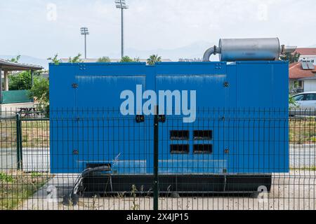 vue arrière gros plan de jumelles métalliques à pièces sur une jetée en béton sur la rive de la mer avec ciel au coucher du soleil en arrière-plan Banque D'Images