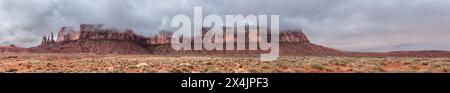 Un panorama de la chaîne de montagnes abritant les célèbres flèches des trois Sœurs à Monument Valley, Arizona sur la gauche de l'image pendant un jour de pluie. Banque D'Images