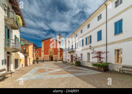 Sanfront, Cuneo, Italie - 03 mai 2024 : Piazza Ferrero pavée de porphyre et de dalles de pierre avec l'église paroissiale de San Martino Banque D'Images