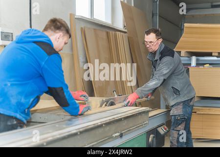 Deux charpentiers travaillant ensemble dans un atelier de menuiserie, des artisans. Photo de haute qualité Banque D'Images