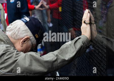 27 avril 2024 - Washington, District of Columbia, États-Unis - Un vétéran de la guerre spéciale navale (NSW) Vietnam pose sa main sur le mur en mouvement au Mémorial des vétérans du Vietnam lors de la tournée d'honneur San Diegos du vol d'honneur du 26 au 28 avril. Un petit groupe d'anciens SEAL et de membres de la force active Naval Special Warfares (NSW) se sont portés volontaires pour servir de gardiens pour 90 vétérans du Vietnam de la NSW lors d'un voyage de trois jours à Washington, DC, honorant leur service et visitant les mémoriaux construits pour leur sacrifice. Le voyage comprenait des visites à la seconde Guerre mondiale, Lincoln, Corée, Vietnam, Marine, et les monuments commémoratifs du corps des Marines et AR Banque D'Images