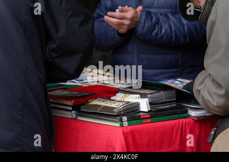 Madrid, Espagne. 11 février 2024 - Groupe de personnes étudiant l'assortiment de timbres postaux de collection. Banque D'Images