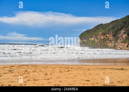 de grandes vagues s'écrasent sur une plage de sable Banque D'Images