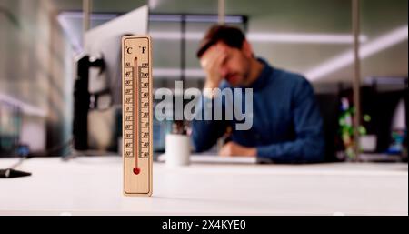 Thermomètre en face de Man par temps chaud dans le bureau Banque D'Images