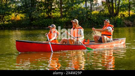 famille canoë sur une rivière à l'été mère et fille pagayant à l'avant, père à l'arrière en allemagne. Famille en kayak. Nature sauvage et eau Banque D'Images