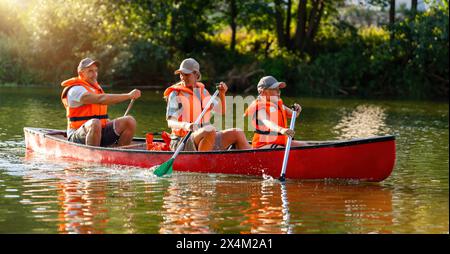 joyeux famille canoë sur une rivière calme à la mère d'été et la fille pagaie à l'avant, père à l'arrière en allemagne. Famille en kayak. Natu sauvage Banque D'Images