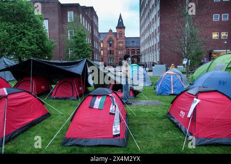 Un manifestant masqué se tient parmi les tentes du camp de résistance grandissant. Étudiants et supporters occupent Brunswick Park à l'Université de Manchester. Les manifestants exigent que l’Université cesse d’armer Israël et mette fin à leur complicité dans le génocide. Ils insistent pour que l’Université mette fin à son partenariat avec le fabricant d’armes BAE Systems, mette fin à ses liens avec tel Aviv et les universités hébraïques en Israël, et adopte une politique garantissant que toute la recherche est éthique et ne contribue pas au commerce des armes. Les manifestants sont déterminés à rester en occupation jusqu'à ce que leurs demandes soient satisfaites Banque D'Images