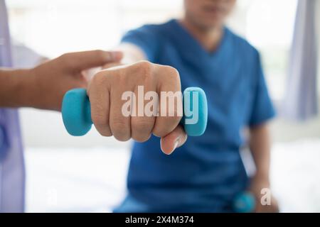 médecin vérifie les blessures musculaires et en utilisant des haltères test blessure et aide également à la thérapie physique renforcer les muscles parce que la thérapie physique Banque D'Images