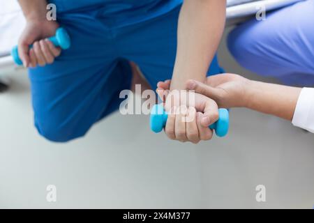 médecin vérifie les blessures musculaires et en utilisant des haltères test blessure et aide également à la thérapie physique renforcer les muscles parce que la thérapie physique Banque D'Images