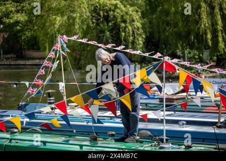 Londres, Royaume-Uni. 4 mai 2024. Un propriétaire décorant son bateau étroit avec des banderoles colorées et d'autres décorations de style festival pendant la Canalway Cavalcade de l'Inland Waterways Association (IWA) à Little Venice pour célébrer le meilleur de la vie sur les voies navigables de Londres et sa communauté. L'événement se déroule au cours du week-end des fêtes bancaires de début mai et célèbre son 41e anniversaire cette année. Credit : Stephen Chung / Alamy Live News Banque D'Images