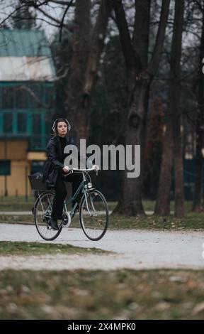 Jeune femme d'affaires élégante à vélo dans un cadre extérieur Banque D'Images