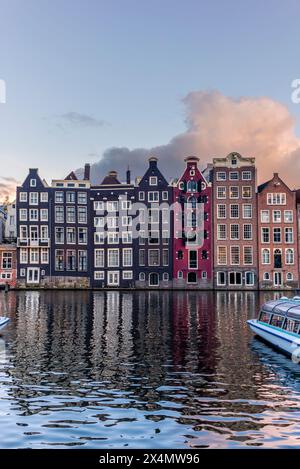Vue sur les maisons de danse du canal Damrak à Amsterdam au coucher du soleil Banque D'Images
