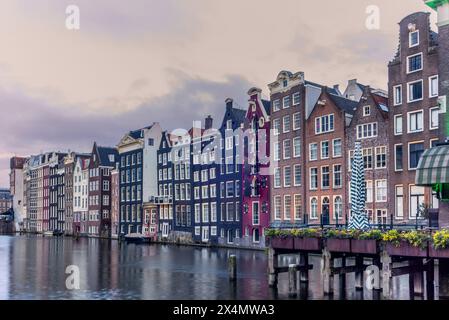 Vue sur les maisons de danse du canal Damrak à Amsterdam au coucher du soleil Banque D'Images