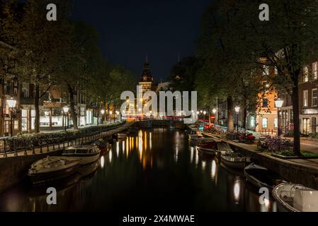 Bateaux et reflet du Rijksmuseum sur le canal Spiegelgracht à Amsterdam la nuit avec des sentiers légers de voitures Banque D'Images