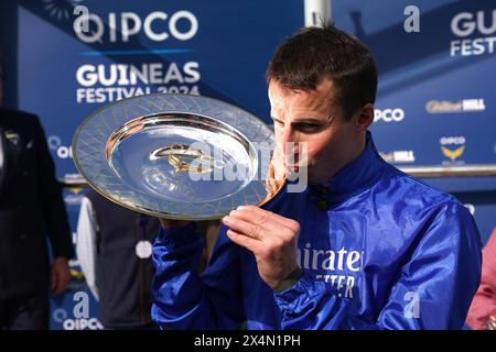 Le jockey William Buick célèbre avec le trophée après avoir remporté le QIPCO 2000 Guineas Stakes avec un discours de cheval remarquable le deuxième jour du QIPCO Guineas Festival à Newmarket Racecourse, Suffolk. Date de la photo : samedi 4 mai 2024. Banque D'Images