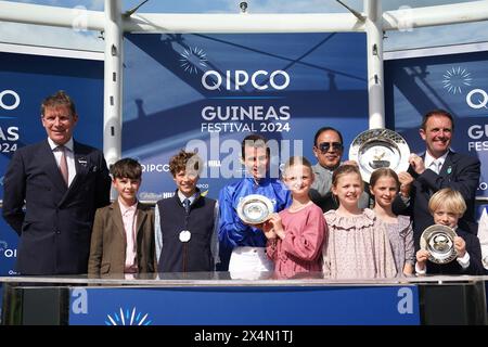 Le jockey William Buick (au centre) et l’entraîneur Charlie Appleby (à droite) célèbrent avec le trophée après avoir remporté les QIPCO 2000 Guineas Stakes avec un discours de cheval remarquable le deuxième jour du QIPCO Guineas Festival à Newmarket Racecourse, dans le Suffolk. Date de la photo : samedi 4 mai 2024. Banque D'Images