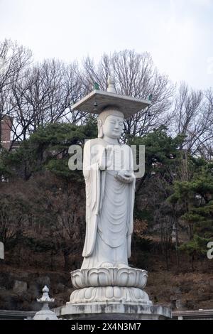 Statue de Mireuk Daebul du bodhisattva Maitreya au temple Bongeunsa, un temple bouddhiste à Séoul. Avec un fond d'hiver au début du printemps. C'est le Banque D'Images