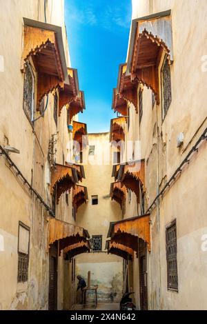 Ruelle étroite avec des auvents en bois ornées dans la médina de Fès. Banque D'Images