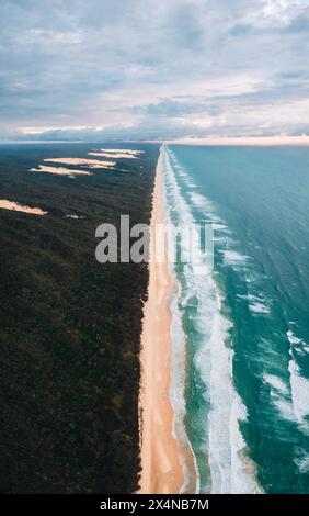 Vue aérienne à grand angle de la célèbre plage Seventy Five Mile Beach, plage de 75 km sur Fraser Island, Kgari, Queensland, Australie, peu avant le coucher du soleil Banque D'Images