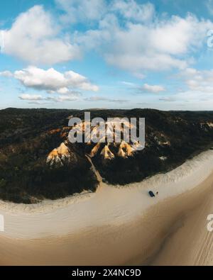 Vue aérienne drone des Pinnacles, sables colorés sur Fraser Island, lever du soleil avec voiture. Kgari, Queensland, Australie. Banque D'Images