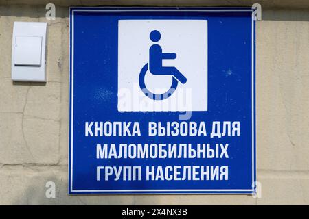 Saransk, Russie - 5 juin 2023. Bouton d'appel pour personnes handicapées. Panneau jaune représentant une personne en fauteuil roulant et un appel b Banque D'Images