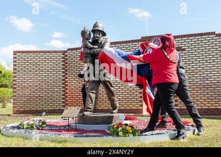 Statue d'un pompier, sauvant un enfant, lors du dévoilement et de l'ouverture du Mémorial national des pompiers de la plaque rouge à Rettendon, Essex, Royaume-Uni. Maire Banque D'Images