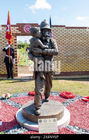 Statue d'un pompier, sauvant un enfant, lors du dévoilement et de l'ouverture du Mémorial national des pompiers de la plaque rouge à Rettendon, Essex, Royaume-Uni Banque D'Images