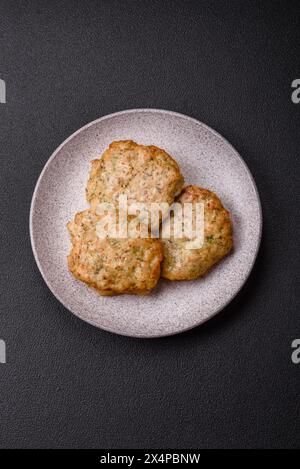 Délicieuses côtelettes de poulet hachées frites avec du sel, des épices et des herbes sur un fond de béton foncé Banque D'Images