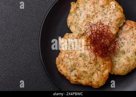 Délicieuses côtelettes de poulet hachées frites avec du sel, des épices et des herbes sur un fond de béton foncé Banque D'Images